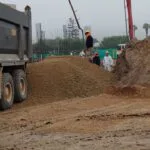 Ingenieros inspeccionando un montículo de base granular en obra de construcción