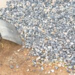 Acumulación de piedra chancada siendo juntada por una pala