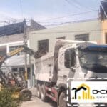 Minicargador bobcat cargando desmonte a volquete blanco. Eliminación de desmonte