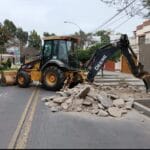 Retroexcavadora John Deere 310J recogiendo desmonte de vereda o calle para eliminación de desmonte